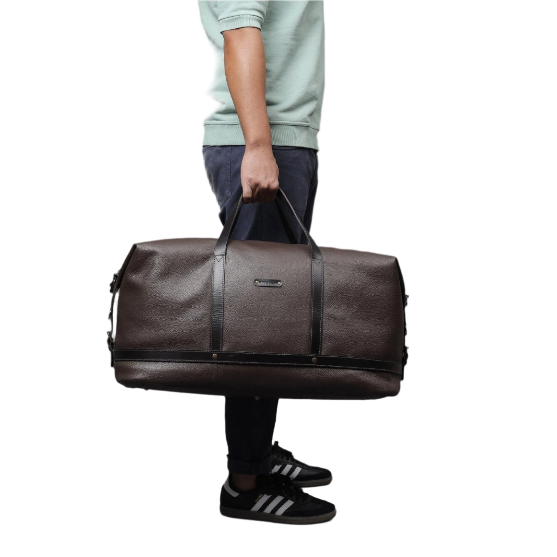 Gentleman carrying stylish and spacious brown leather duffel bag/weekender